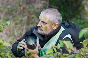 war photographer camouflaged in the vegetation